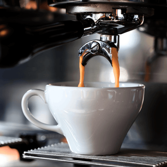 Freshly brewed coffee pouring from a coffee machine into a cup, highlighting the rich aroma and morning ritual appeal of coffee