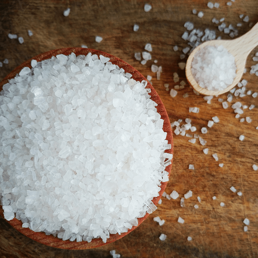 A ceramic bowl filled with coarse Epsom salt crystals, ready for a relaxing bath soak
