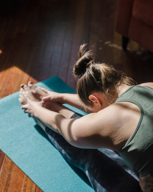 Person practicing somatic stretching, focusing on mindful movement and deep body awareness to release tension and promote emotional and physical healing.