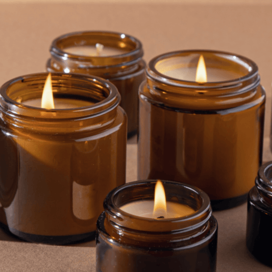 Natural beeswax candles burning in glass jars, creating a warm and cosy glow in a toxin-free home environment