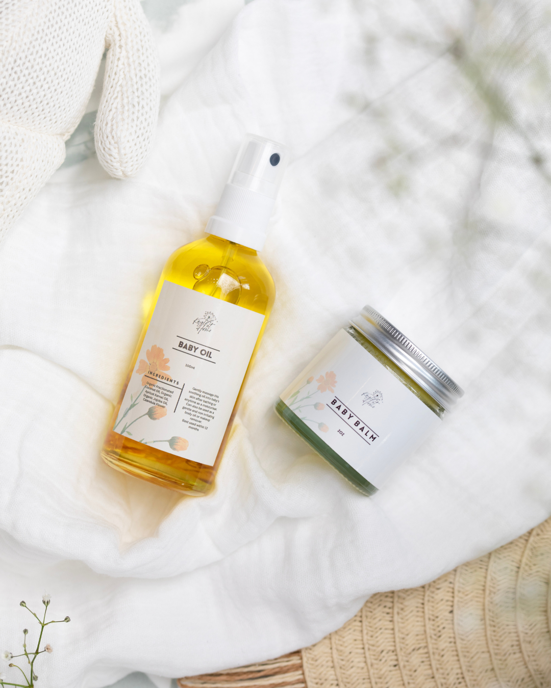 Organic Baby Oil and Baby Balm on a soft neutral blanket – natural skincare for babies by Kayle at Home