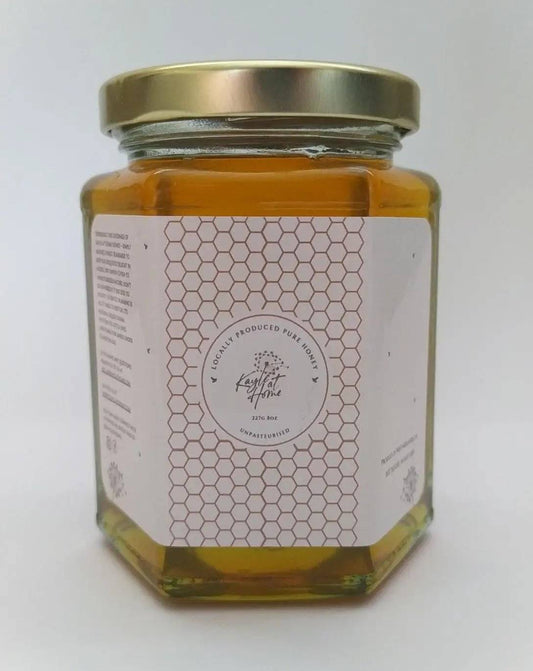a jar of honey sitting on a white surface