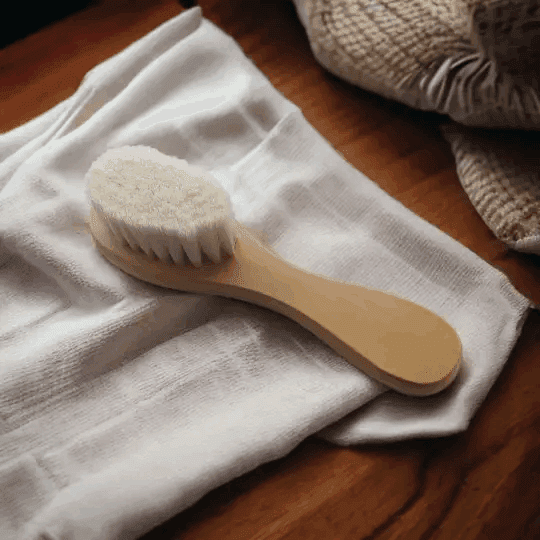 a wooden brush sitting on top of a white cloth