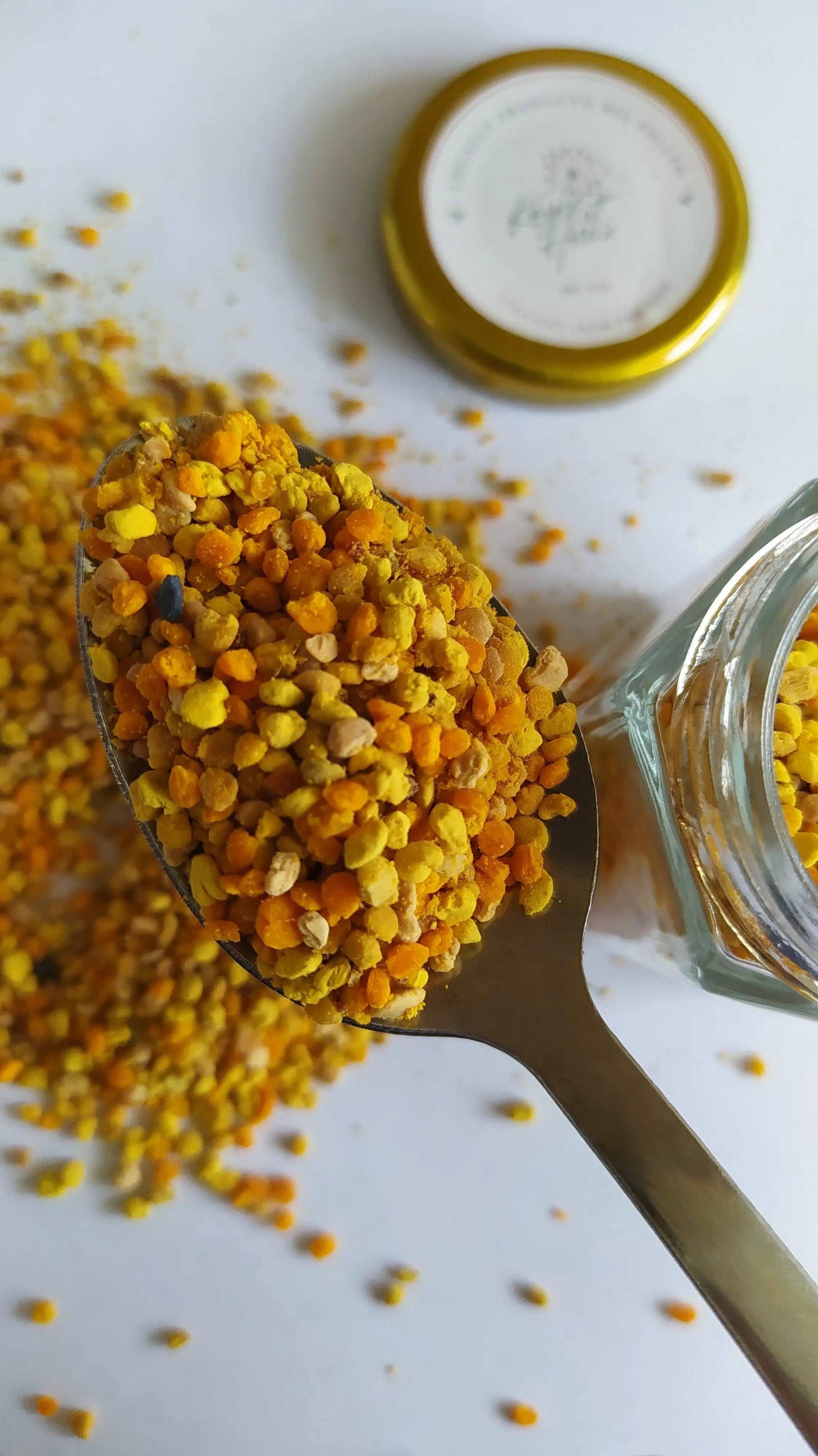a spoon full of yellow corn next to a jar of mustard